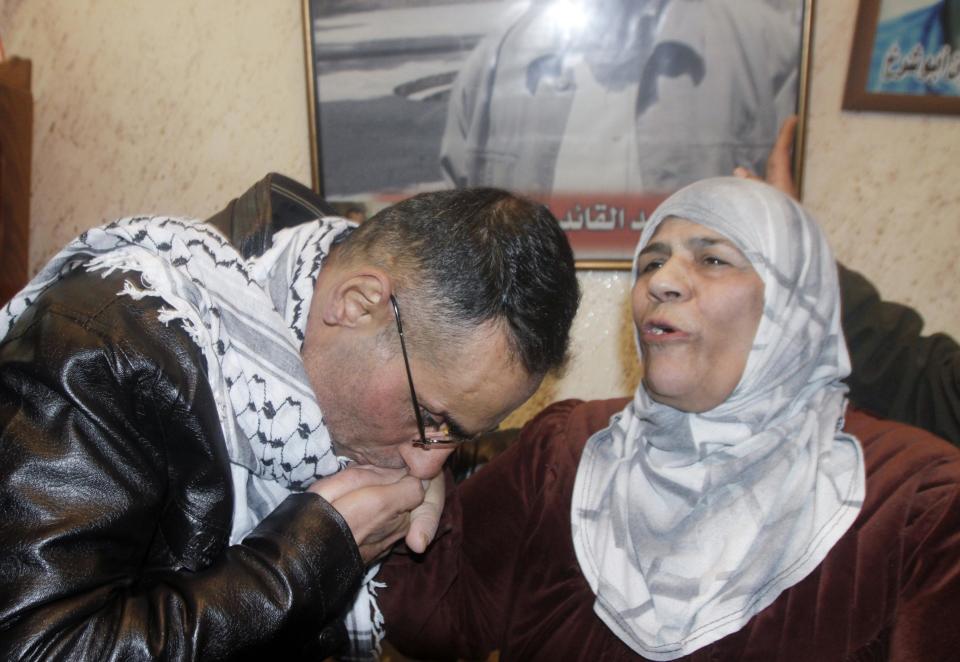 Newly released Palestinian prisoner Taktook kisses his aunt's hand upon his arrival at his home in Nablus