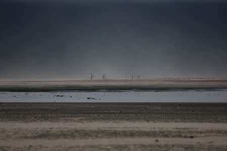 Sand blows across a normally submerged area at Theewaterskloof dam near Cape Town, South Africa, January 20, 2018. The dam, which supplies most of Cape Town's potable water, is currently dangerously low as the city faces "Day Zero", the point at which taps will be shut down across the city. REUTERS/Mike Hutchings