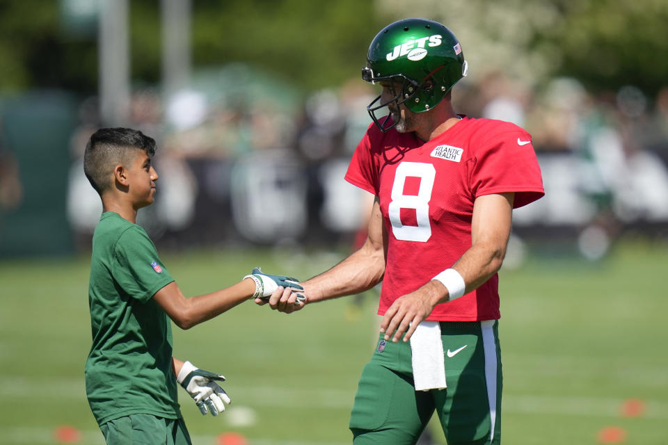 New York Jets quarterback Aaron Rodgers, right, greets a kid during a practice session at the NFL football team's training facility in Florham Park, N.J., Sunday, July 30, 2023. (AP Photo/Seth Wenig)