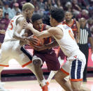 Virginia Tech's Jalen Cone (15) is defended by Virginia's Mamadi Diakite (25) and Kihei Clark (0) during the first half of an NCAA college basketball game Wednesday, Feb. 26, 2020, in Blacksburg, Va. (Matt Gentry/The Roanoke Times via AP)