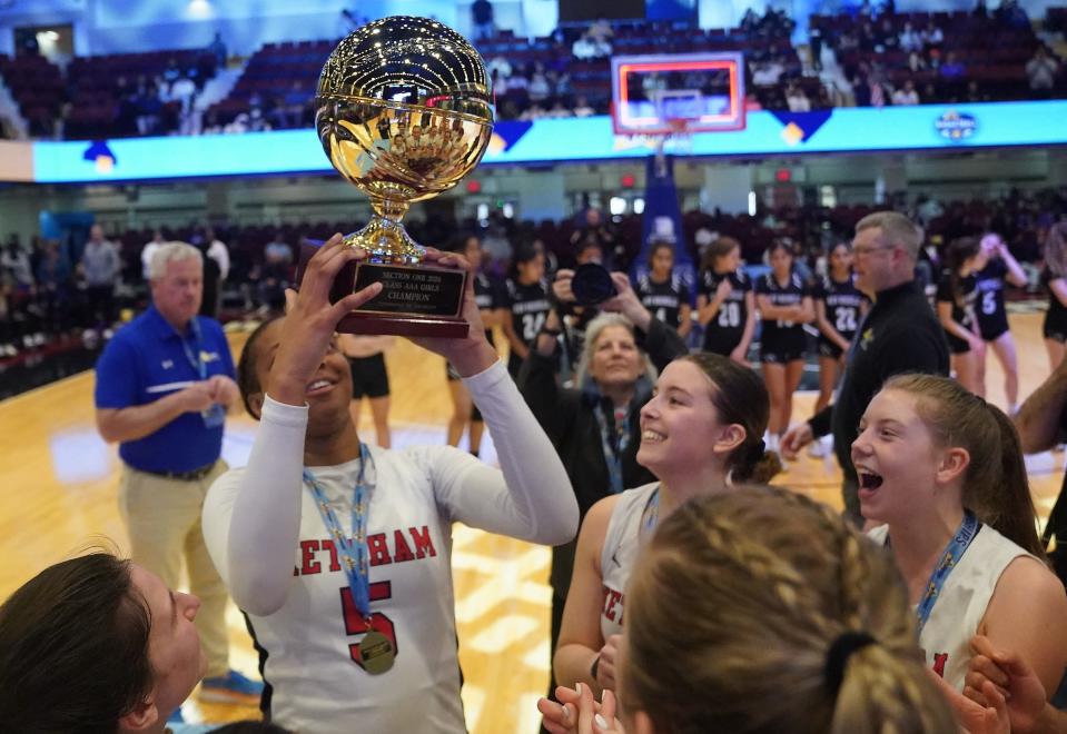 Ketcham's Nia Rencher (5) hoists the Gold Ball trophy in the air after winning the Section 1 Class AAA girls basketball championship on March 3, 2024.