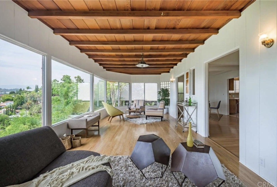 A living area with large floor to ceiling windows and neutral decor