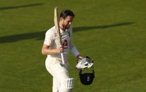 England's Chris Woakes raises his bat as walks off the field after their win during the fourth day of the first cricket Test match between England and Pakistan at Old Trafford in Manchester, England, Saturday, Aug. 8, 2020. (Lee Smith/Pool via AP)