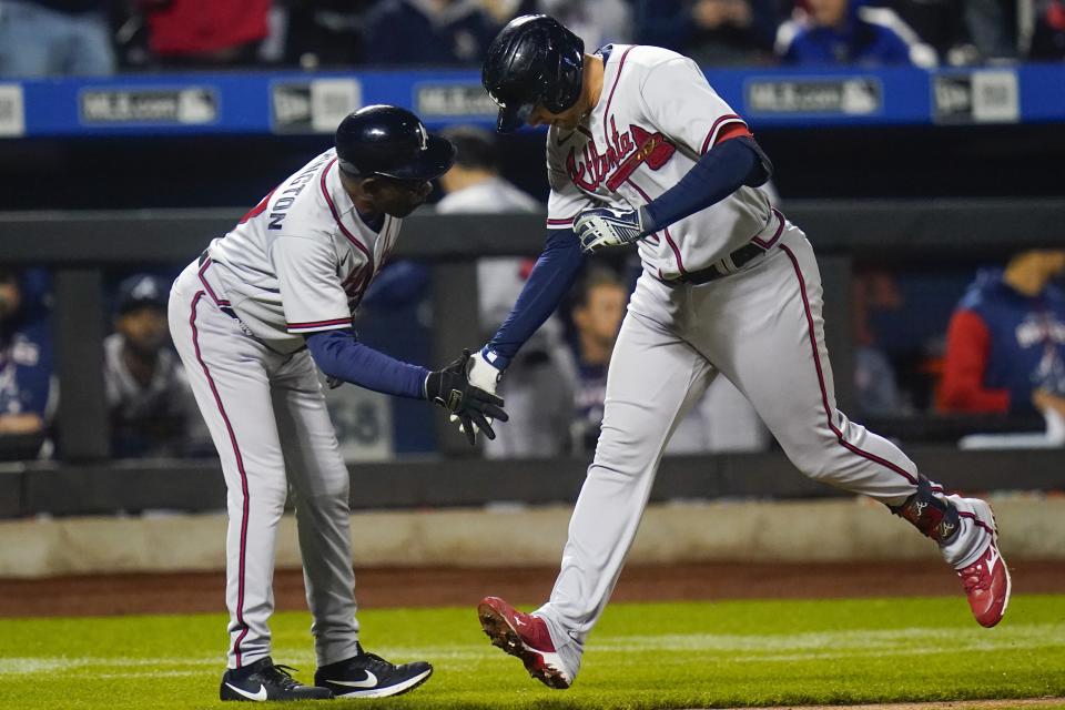 Atlanta Braves' Austin Riley, right, celebrates with third base coach Ron Washington as he runs the bases after hitting a home run during the fourth inning of a baseball game against the New York Mets, Monday, May 2, 2022, in New York. (AP Photo/Frank Franklin II)