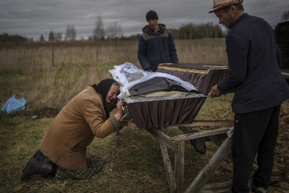 FILE - Nadiya Trubchaninova, 70, cries while holding the coffin of her son Vadym, 48, who was killed by Russian soldiers last March 30 in Bucha, during his funeral in the cemetery of Mykulychi, on the outskirts of Kyiv, Ukraine, Saturday, April 16, 2022. Trubchaninova hitchhiked daily from her village to the shattered town of Bucha trying to bring her son's body home for burial. As their advance to Kyiv stalled and losses mounted, Russian troops continued to cleanse the streets of Bucha and surrounding towns with rising levels of sometimes drunken violence. (AP Photo/Rodrigo Abd, File)