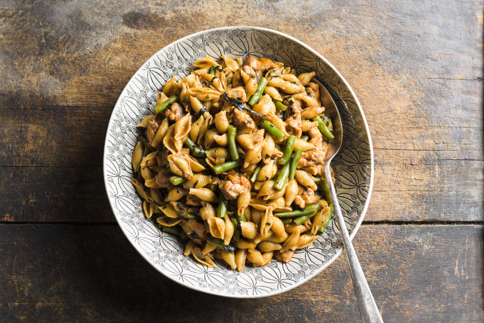 This image released by Milk Street shows a recipe for harissa-spiced pasta with chicken and green beans. (Milk Street via AP)