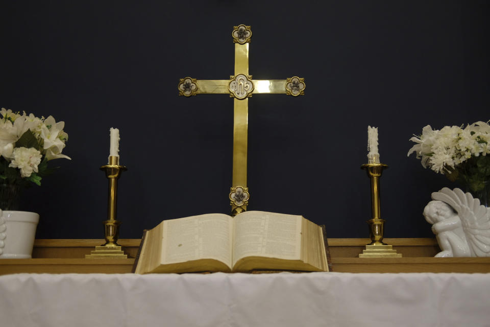 A cross and open Bible are seen at the altar at Turning Point United Methodist Church in Trenton, N.J. on Monday, May 13, 2024. Earlier this month, delegates at a United Methodist conference struck down longstanding anti-LGBTQ bans and created a path for clergy ousted because of them to seek reinstatement. (AP Photo/Luis Andres Henao)