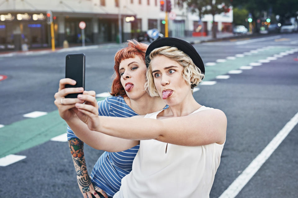 two women taking a tongue-out selfie