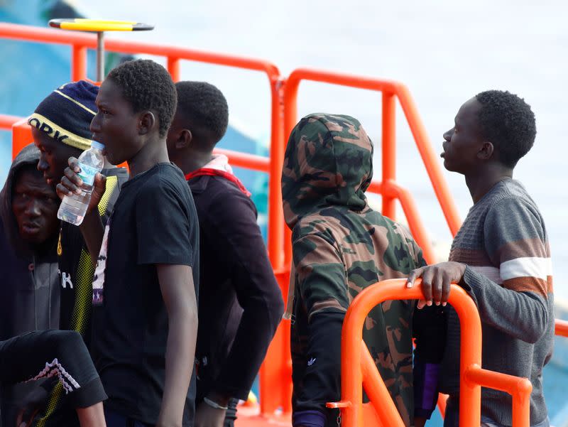 Migrants wait to disembark from a Spanish coast guard vessel in the port of Arguineguin on the island of Gran Canaria