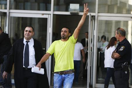 An Israeli Arab man (C) flashes a victory sign after his sentencing at the district court in the northern city of Haifa November 28, 2013. REUTERS/Nir Elias