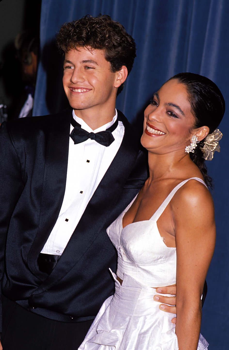 <p>The young stars of "A Different World" arrive together—her in a two-piece white bustier and ruffled skirt, him in a classic tux.</p>