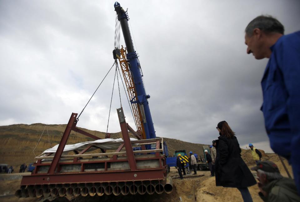 A crane lifts the skeleton of a female southern mammoth named Vika at an open pit coal mine in Kostolac, 80 kilometers (50 miles) east of Belgrade, Serbia, Friday, April 11, 2014. Vika, a complete mammoth skeleton, discovered by Serbian archaeologists in 2009 inside the Kostolac open coal pit mine, was moved from the spot where it was found to a secure location because the pit mine threatened to endanger the safety of the remains. (AP Photo/Darko Vojinovic)