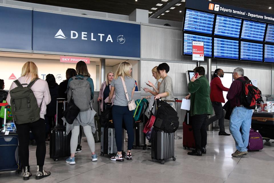 Travellers queue at a Delta Airlines desk at Paris-Charles-de-Gaulle airport after a US 30-day ban on travel from Europe due to the COVID-19 spread in Roissy-en-France on March 12, 2020. - US President Donald Trump announced on March 11, 2020 a shock 30-day ban on travel from mainland Europe over the coronavirus pandemic that has sparked unprecedented lockdowns, widespread panic and another financial market meltdown. (Photo by Bertrand GUAY / AFP) (Photo by BERTRAND GUAY/AFP via Getty Images)