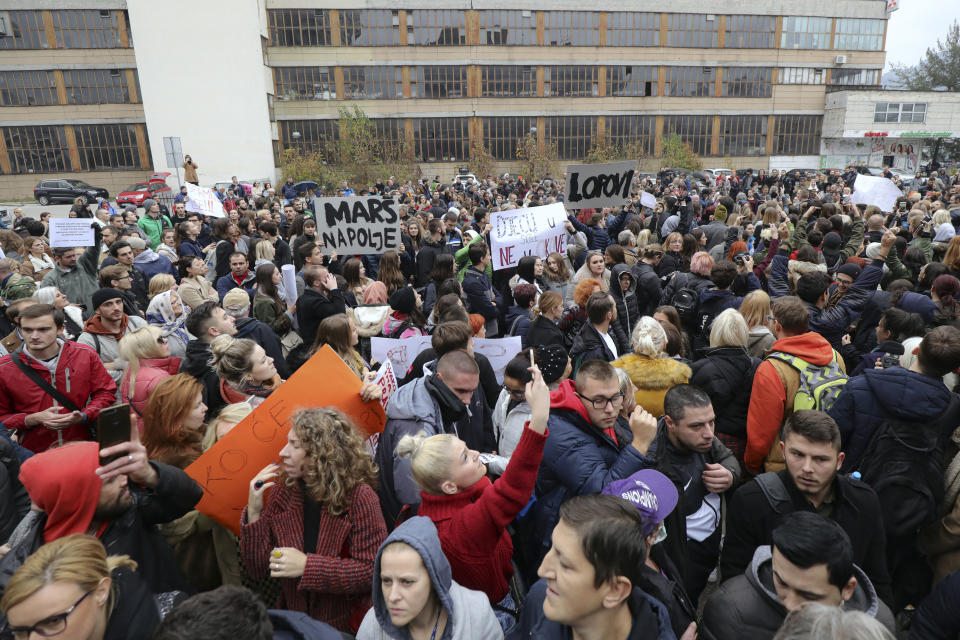 People attend a protest in Sarajevo, Bosnia, Thursday, Nov. 21, 2019. Protesters in Bosnia have rallied outside the government building in Sarajevo after opposition lawmaker Sabina Cudic published shocking photos of special needs children tied to beds and radiators in a nearby government facility. The protest Thursday by 1,000 people included scores of parents of children with disabilities, who described a dysfunctional care system that condemns their kids to suffering and excludes them from society. (AP Photo/Almir Alic)