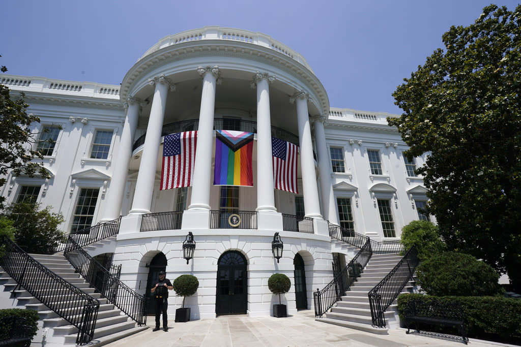 American flags and a pride flag hang from the White House during a Pride Month.