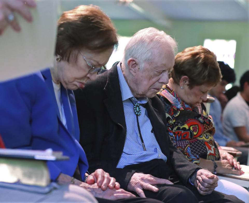 President Jimmy Carter and Rosalynn Carter bow their heads in prayer with members and visitors during the worship service at Maranatha Baptist Church less than a month after the 39th U.S. president and Plains native fell breaking his hip, on June 9, 2019, in Plains, Ga. (Curtis Compton/Atlanta Journal-Constitution via AP)