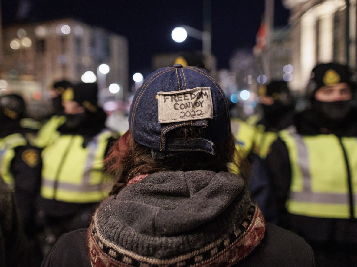 A protester faces police near Parliament Hill in Ottawa on Feb. 18. (Evan Mitsui/CBC - image credit)