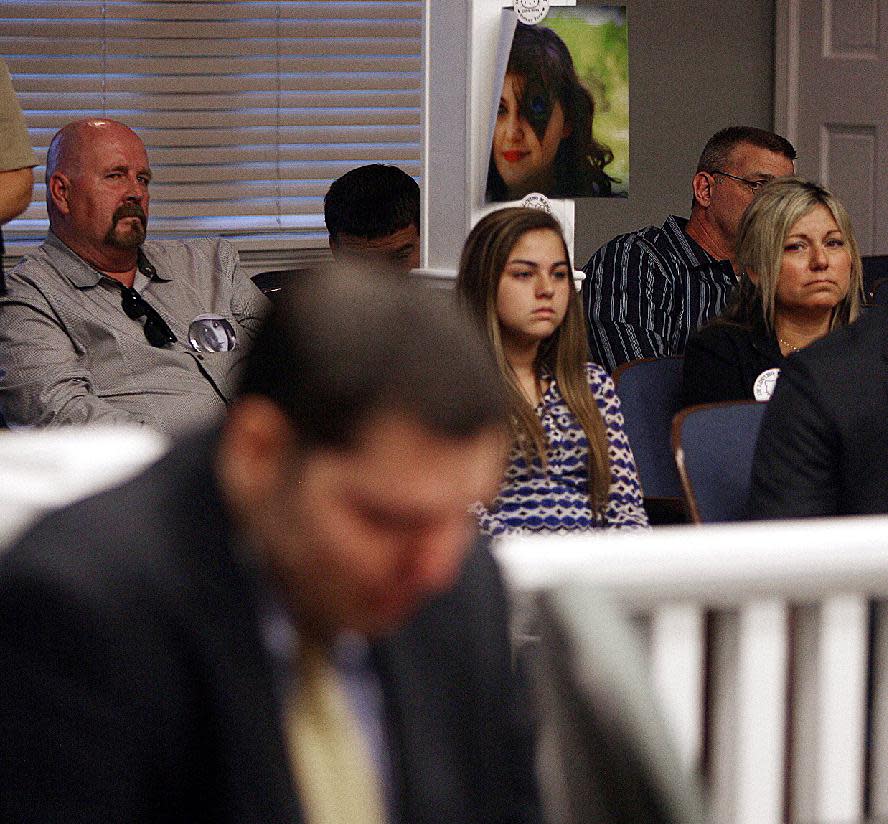 A photo of Tiffany York hangs in court Thursday May 1, 2014, in Ludowici, Ga., as her mother Brenda Thomas, right, and her daughter Kendell Thomas, listen to the court proceedings of Army Sgt Anthony Peden who plead guilty to the slaying of Tiffany York. Peden was sentenced to life in prison Thursday by a southeast Georgia judge for the December 2011 slayings of 17-year-old Tiffany York and her boyfriend, former soldier Michael Roark. (AP Photo/Lewis Levine)