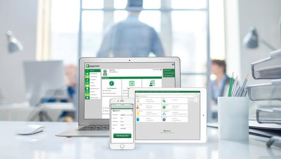 A variety of Paycom software screens on a laptop, tablet and smartphone.