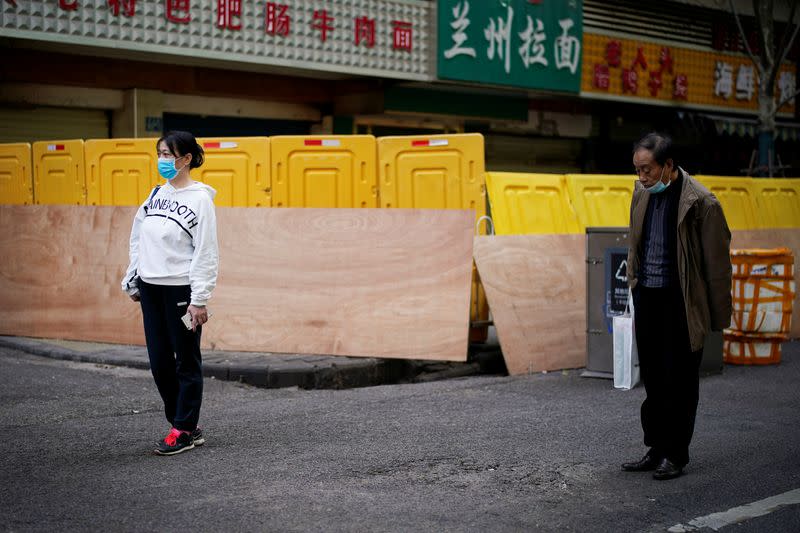 People observe a moment of silence on a street in Wuhan