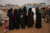 Syrian women wait for donated food to be distributed in a refugee camp for displaced people supported by the Turkish Red Crescent in Sarmada district, north of Idlib city, Syria, Thursday, Nov. 25, 2021. (AP Photo/Francisco Seco)