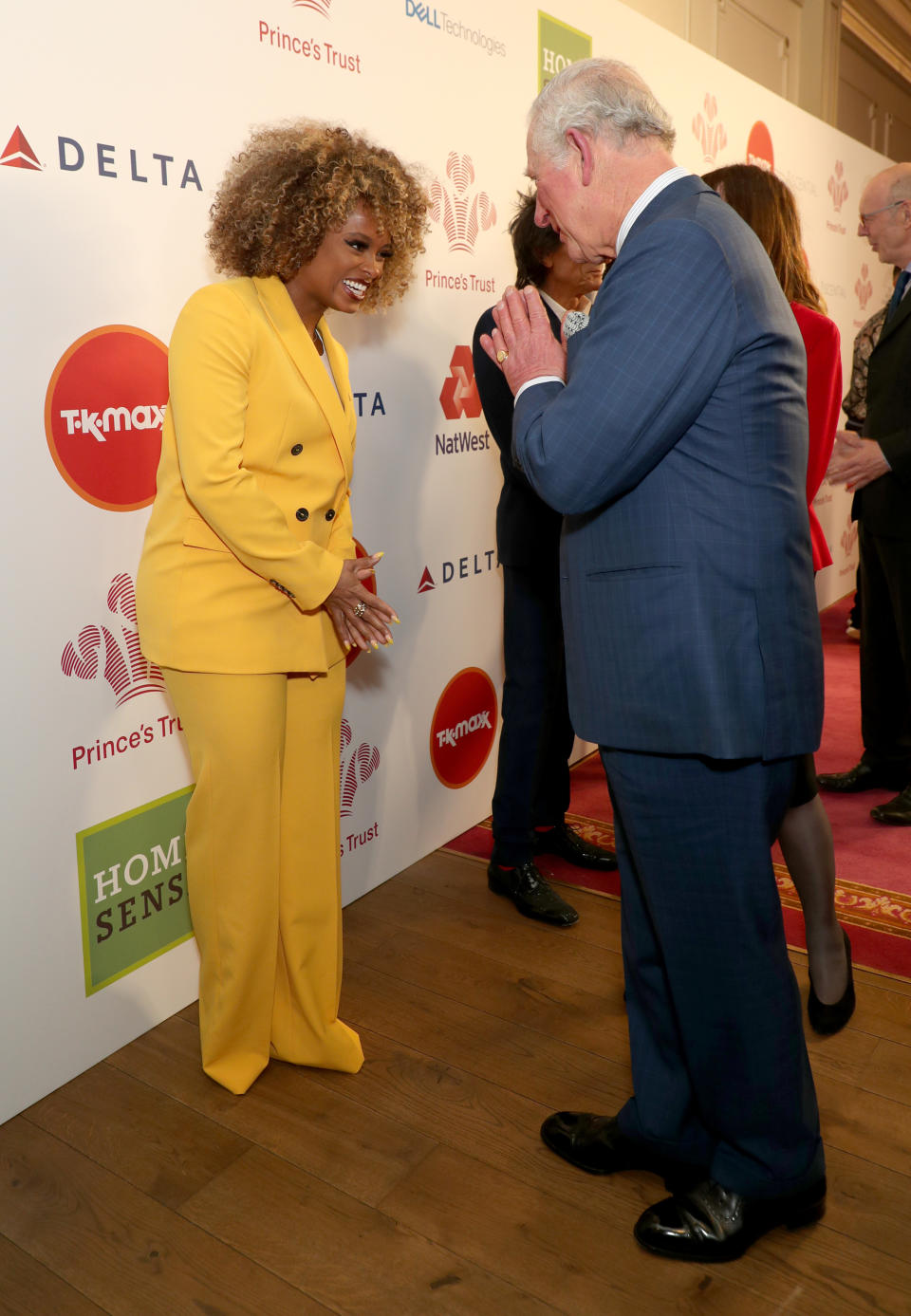 The Prince of Wales uses the Namaste gesture to greet Fleur East as he arrives at the annual Prince's Trust Awards 2020 held at the London Palladium.
