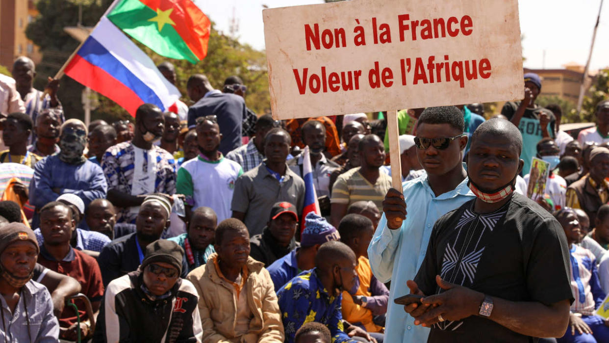People hold a sign as they gather to show their support to Burkina Faso's new military leader Ibrahim Traore and demand the departure of the French ambassador at the Place de la Nation in Ouagadougou, Burkina Faso January 20, 2023. The sign reads : 