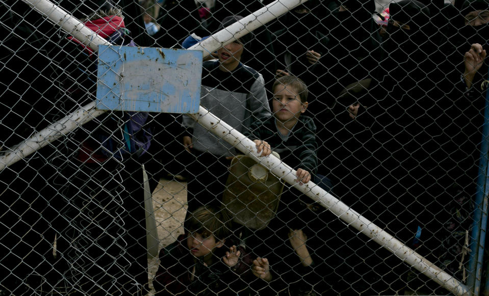 In this March 31, 2019 photo, children peer from the gate that closes off the section for foreign families who live in the Islamic State group's so-called caliphate, at Al-Hol camp in Hassakeh province, Syria. Al-Hol camp is home to 73,000 people who streamed out of the Islamic State group’s last pockets, including the village of Baghouz, the final site to fall to the SDF in March. Nearly the entire population of the camp is women or children, since most men were taken for screening by the SDF to determine if they were fighters. (AP Photo/Maya Alleruzzo)