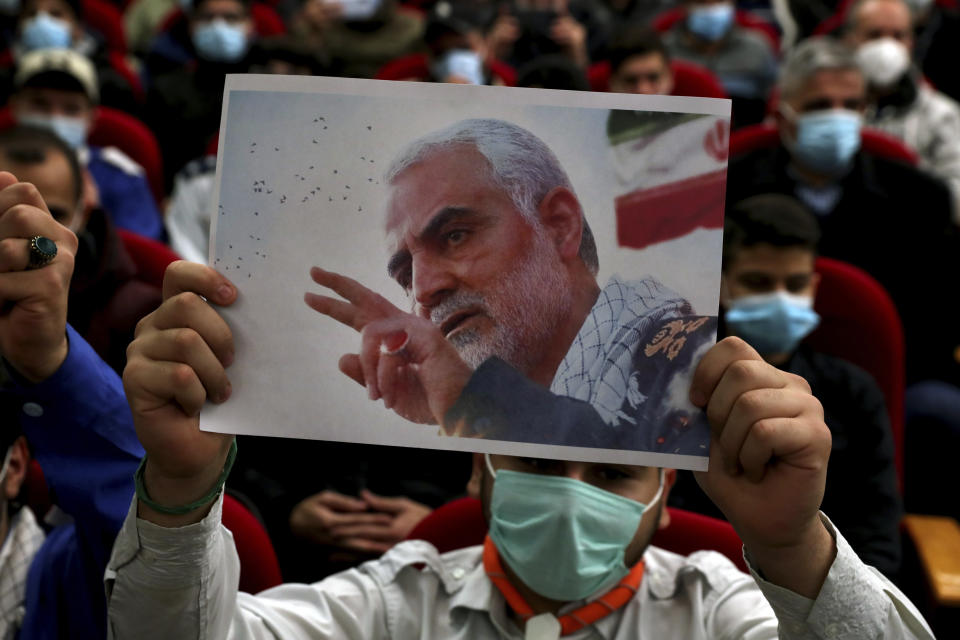 A man holds up a picture of the head of Iran's Quds force General Qassem Soleimani, who was killed in a U.S. drone strike in Baghdad, during a ceremony to mark the second anniversary of his assassination, in the southern Beirut suburb of Dahiyeh, Lebanon, Monday, Jan. 3, 2022. (AP Photo/Bilal Hussein)