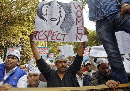 Supporters of Aam Aadmi Party (AAP) hold placards and shout slogans behind a police barricade during a protest against the rape of a female taxi passenger, in New Delhi December 8, 2014. REUTERS/Anindito Mukherjee