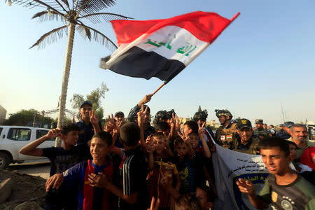 Iraqi Federal police and boys celebrate in West Mosul, Iraq July 9, 2017. REUTERS/Alaa Al-Marjani