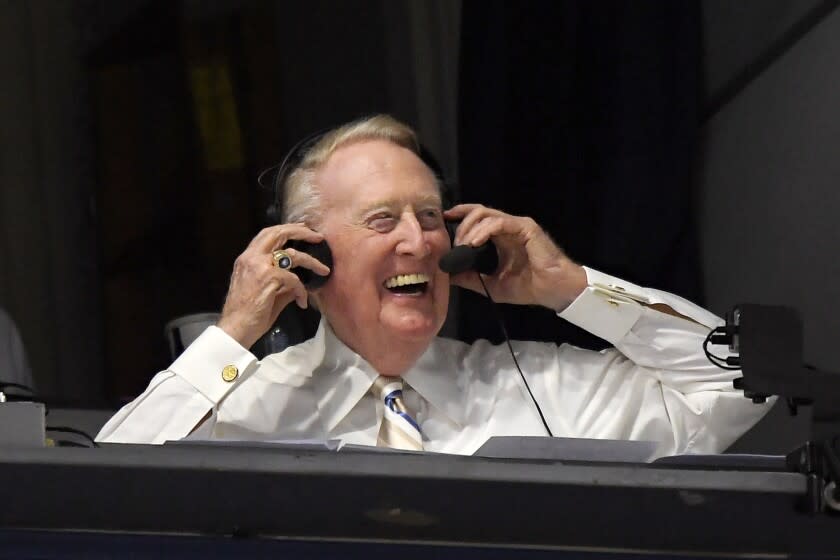 Dodgers Hall of Fame announcer Vin Scully puts his headset on prior to a baseball game