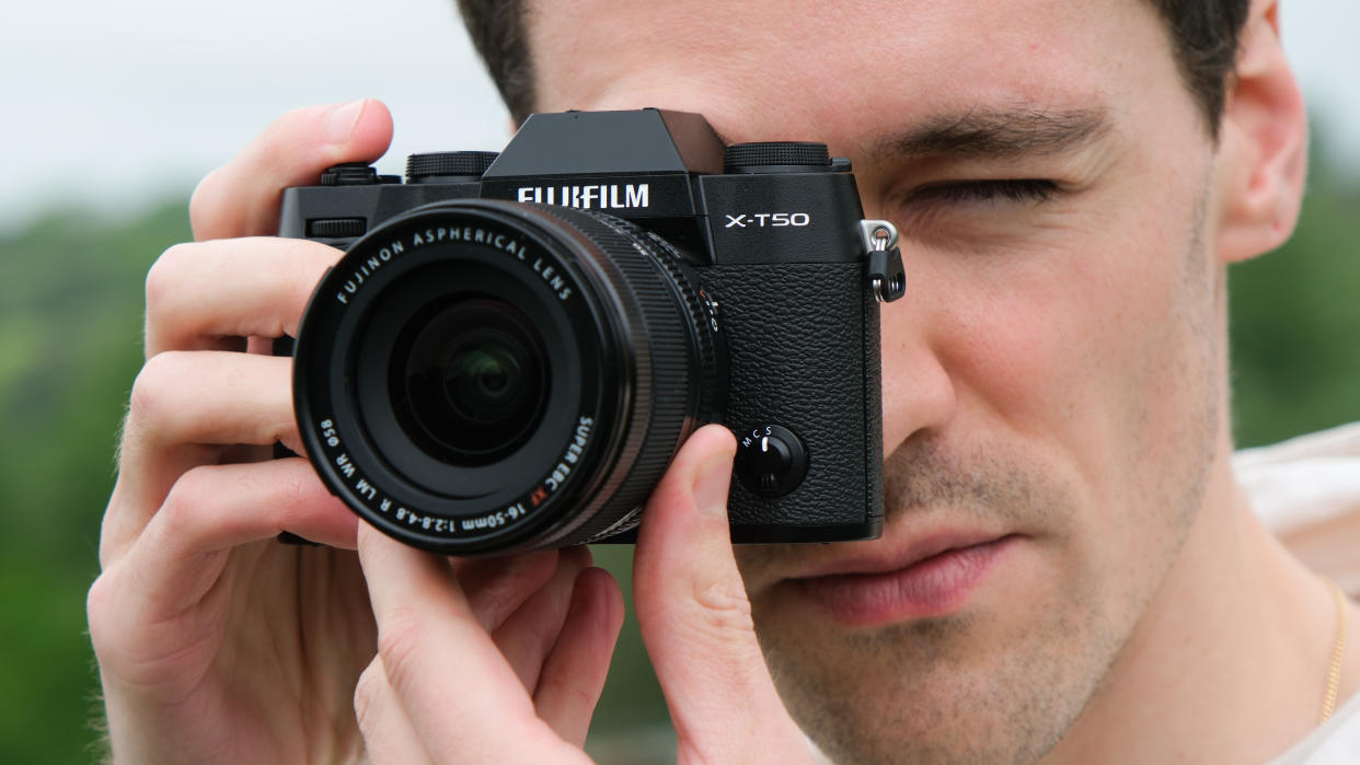  Fujifilm X-T50 camera held up a man's face. 