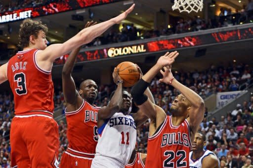 Jrue Holiday (C) of the Philadelphia 76ers goes for a shot while being defended by Omer Asik (L), Luol Deng and Taj Gibson of the Chicago Bulls in Game Six of the Eastern Conference Quarterfinals in the 2012 NBA Playoffs at the Wells Fargo Center, on May 10, in Philadelphia, Pennsylvania. The 76ers won the game 79-78 and took the series 4-2