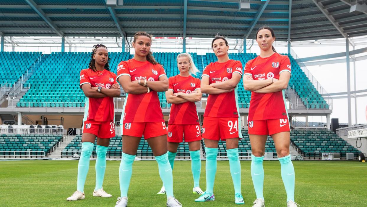 a group of women in red uniforms on a field