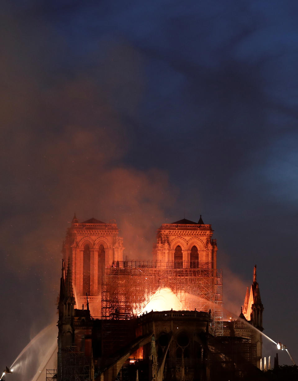 Firefighters douse flames from the burning Notre Dame Cathedral in Paris. Source: Reuters