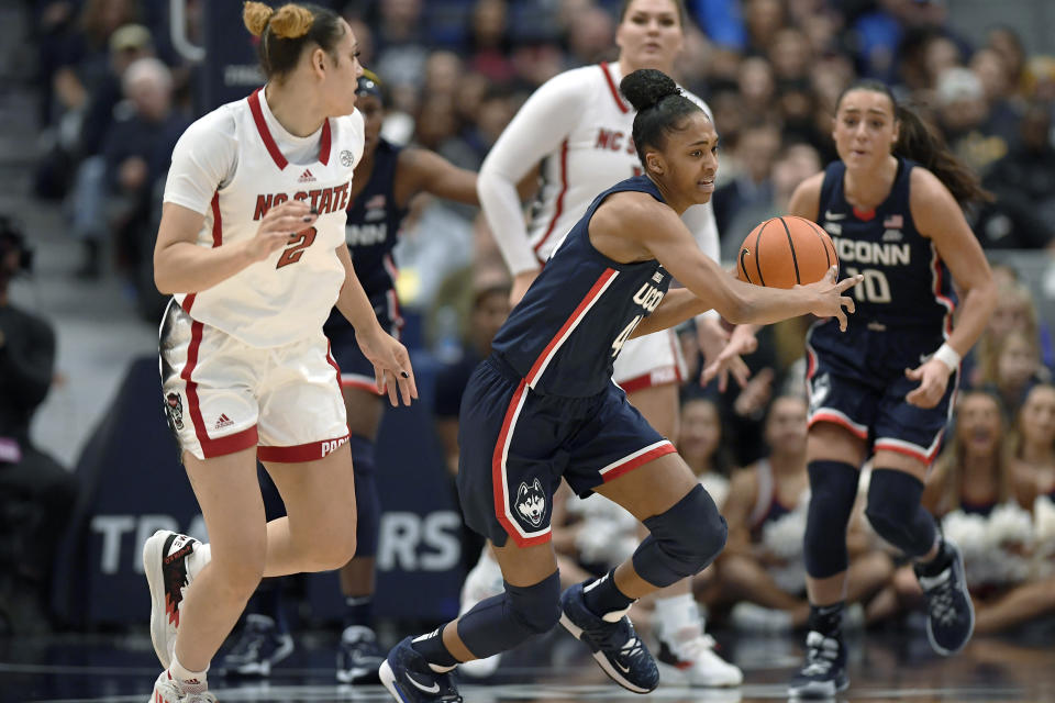 Connecticut's Aubrey Griffin, center, steals the ball from NC State's Mimi Collins, left, during the first half of an NCAA basketball game, Sunday, Nov. 20, 2022, in Hartford, Conn. (AP Photo/Jessica Hill)