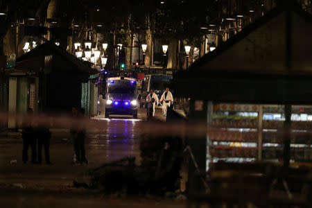 Forensic police officers search for clues near the area where a van crashed into pedestrians at Las Ramblas in Barcelona, Spain, August 17, 2017. REUTERS/Sergio Perez