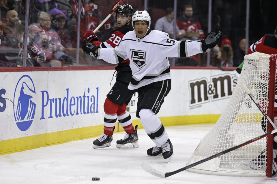 Los Angeles Kings center Quinton Byfield (55) reacts after losing his stick while battling for the puck with New Jersey Devils defenseman Damon Severson (28) during the first period of an NHL hockey game Sunday, Jan. 23, 2022, in Newark, N.J. (AP Photo/Adam Hunger)