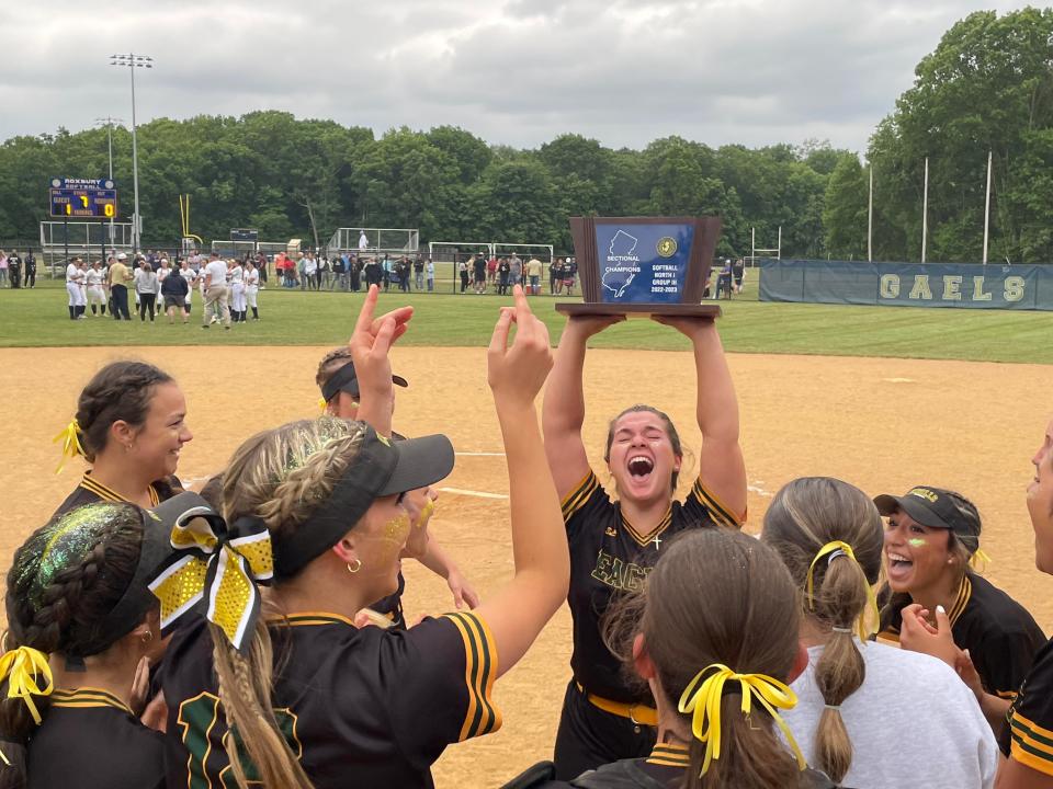 Morris Knolls senior Abby Freidman (center) holds the North 1, Group 3 sectional championship trophy over her head as the Golden Eagles celebrate on Saturday, June 3, 2023.