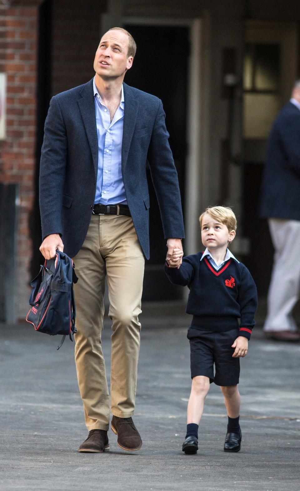 Prince William holding Prince George's hand as he arrives for his first day of school on September 7, 2017.