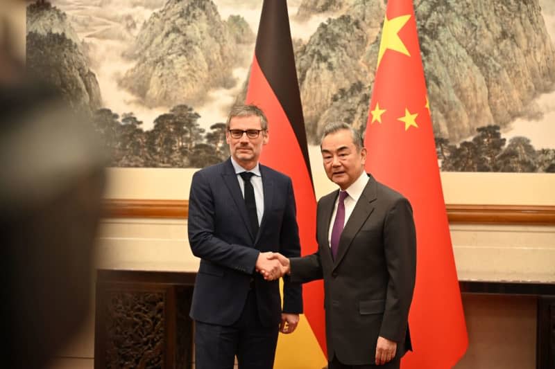 Jens Ploetner (L), Advisor to the German Chancellor for Foreign and Security Policy, stands next to China's Foreign Minister Wang Yi. German diplomats met with Chinese politicians in Beijing on 23 February to discuss various bilateral and global political issues. Johannes Neudecker/dpa