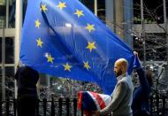 FILE PHOTO: Workers replace the British flag outside the European Parliament building with the European Union flag, as Britain leaves the European Union, in Brussels
