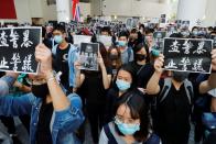 Students attend a ceremony to pay tribute to Chow Tsz-lok, 22, a university student who fell during protests at the weekend and died early on Friday morning, at the Hong Kong University of Science and Technology