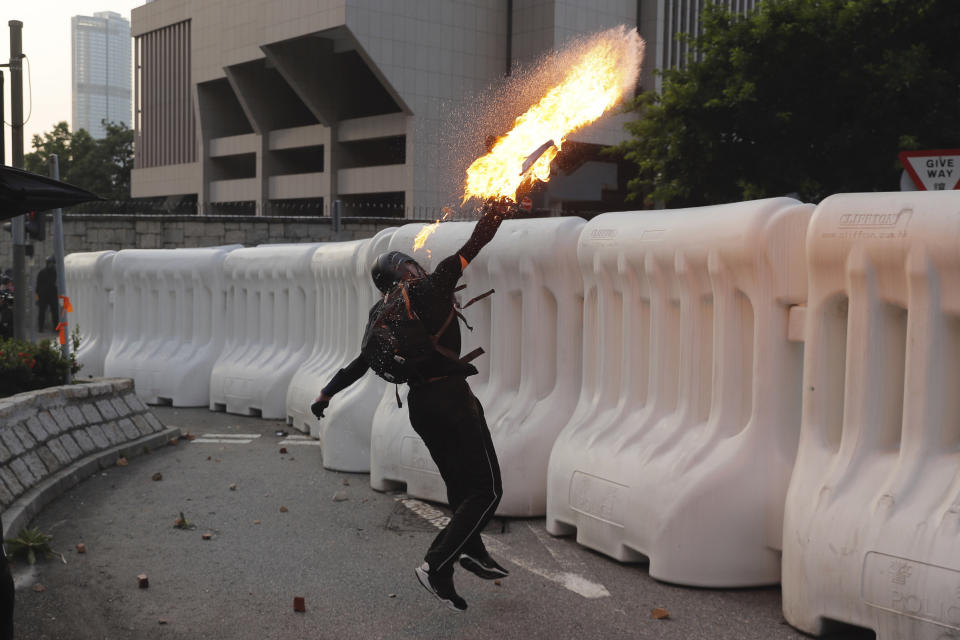 An anti-government protester throws a Molotov cocktail during a demonstration near Central Government Complex in Hong Kong, Sunday, Sept. 15, 2019. Police fired a water cannon and tear gas at protesters who lobbed Molotov cocktails outside the Hong Kong government office complex Sunday, as violence flared anew after thousands of pro-democracy supporters marched through downtown in defiance of a police ban. (AP Photo/Kin Cheung)