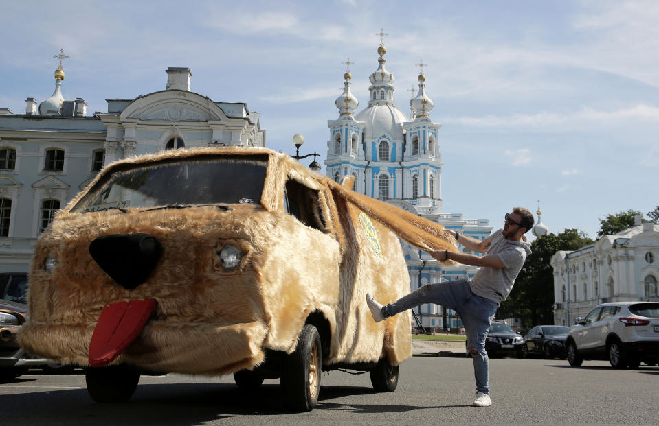 El blogger y actor ruso Roman Pritula posa con su Dogmobile, un vehículo que creó a partir de una Volkswagen antigua, cerca de la Catedral Smolny de San Petersburgo (Rusia) el 25 de julio. (Foto: Anton Vaganov / Reuters).