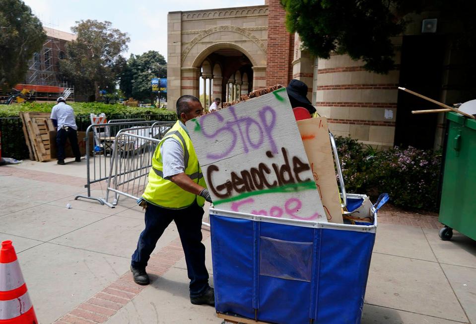 Protest signs are hauled away as crews clean up in the aftermath of the UCLA pro-Palestinian encampment at the campus of UCLA on May 2, 2024. Law enforcement officers broke up the encampment in the early morning hours and over 200 were arrested. The encampment was across from Royce Hall to show support for Palestinians in the Gaza conflict.