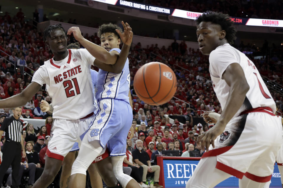 North Carolina State forward Greg Gantt (21) and guard Jarkel Joiner, right, along with North Carolina forward Puff Johnson, center, watch the ball during the first half of an NCAA college basketball game, Sunday, Feb. 19, 2023, in Raleigh, N.C. (AP Photo/Chris Seward)