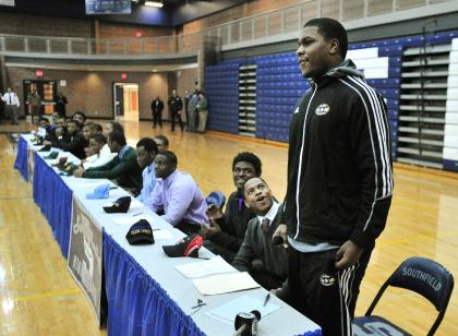 Teammates and schoolmates react after Malik McDowell, right, announces he will be attending Michigan State University to play football during a national signing day ceremony at Southfield High School's gym in Southfield, Mich., Wednesday, Feb. 5, 2014. (AP Photo/Detroit News, Daniel Mears )