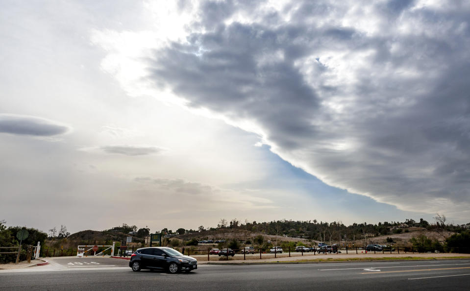 In a view from Peters Canyon Regional Park in Orange, Calif., a line of storm clouds moves across Orange County as strong Santa Ana winds began to blow early Tuesday afternoon, Jan. 19, 2021, throughout Orange County and Southern California. (Mark Rightmire/The Orange County Register via AP)